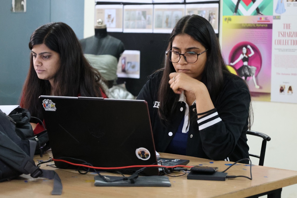 Students working on laptops in digital design studio at CODE