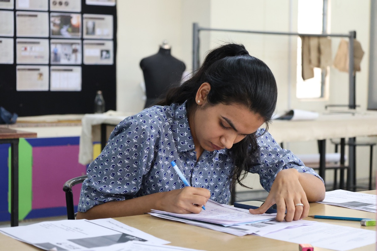 Student sketching in fashion design studio at CODE